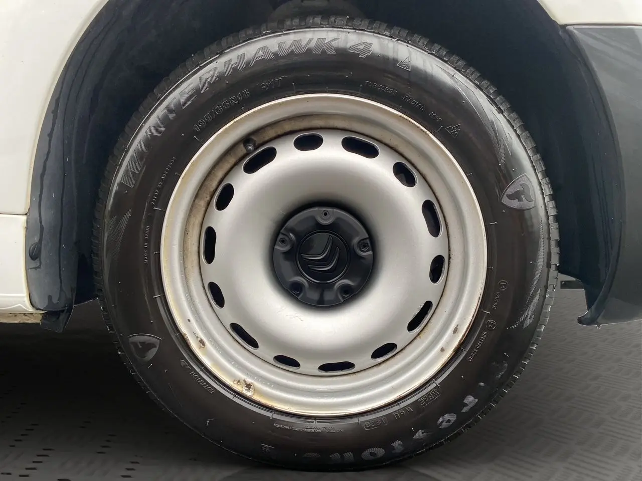 Gros plan sur la roue avant droite blanche d’un Citroën Berlingo 2018 avec pneu Firestone Winterhawk 4.