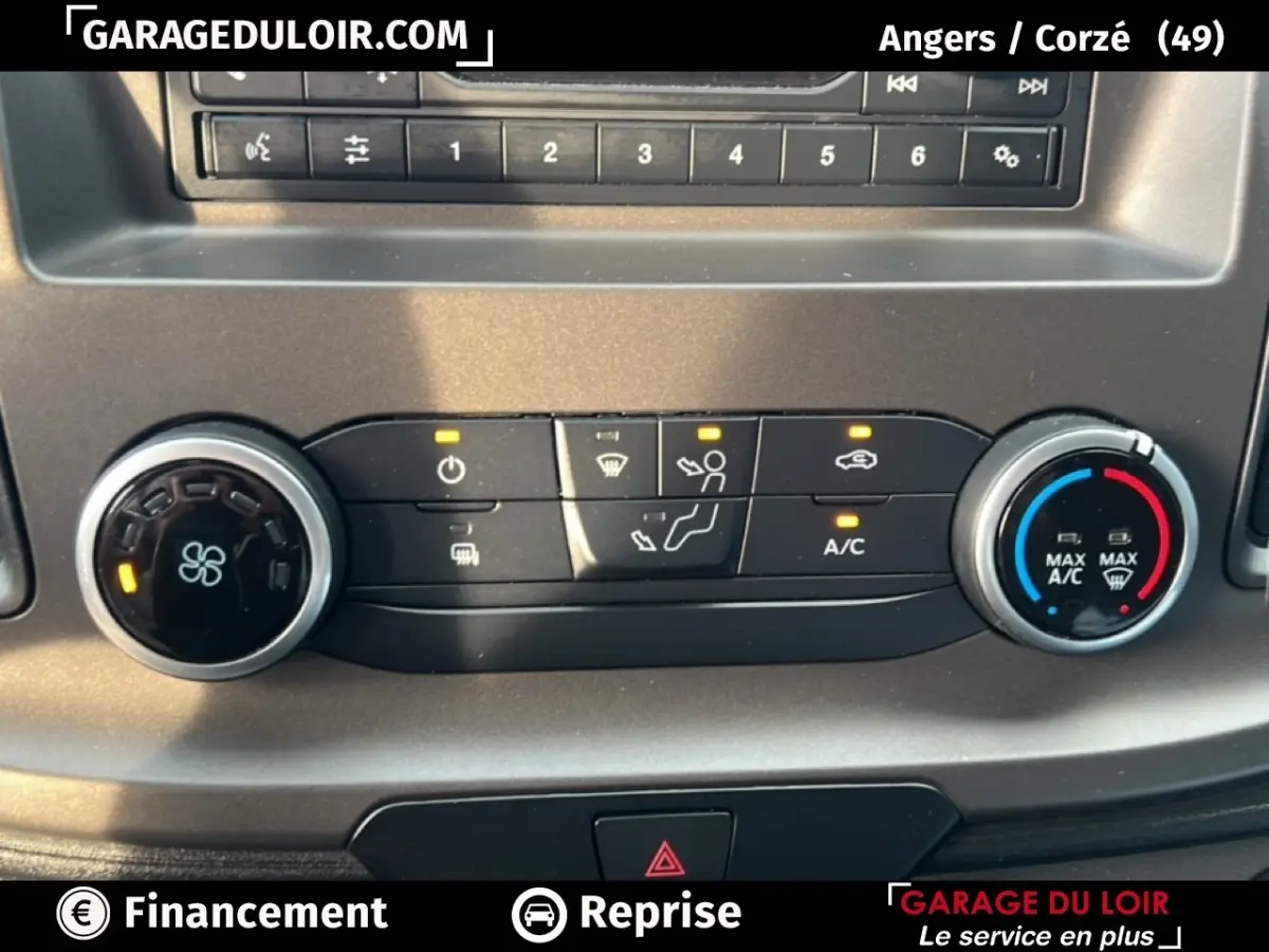 Détail du tableau de bord du Ford Transit Custom blanc 2023 montrant les commandes de climatisation et ventilation.