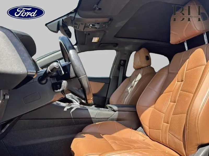 Vue intérieure côté conducteur du DS7 Crossback 2020, sièges cuir brun Alezan et toit ouvrant panoramique visible.