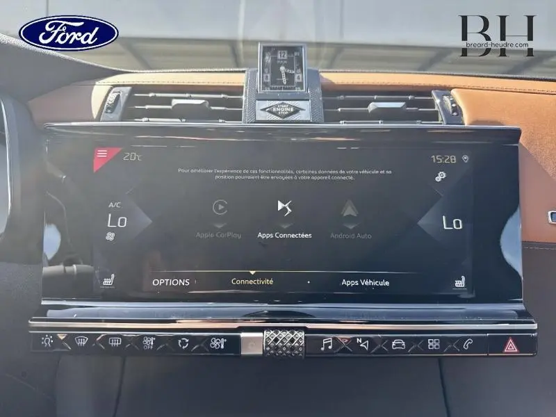 Vue rapprochée du tableau de bord du DS7 Crossback gris Artense, mettant en valeur l'écran tactile et l'horloge centrale.