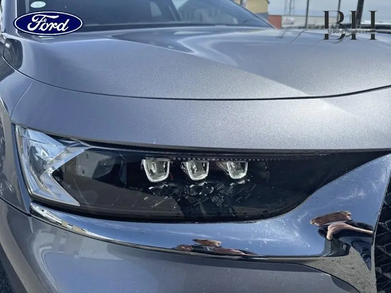 Gros plan sur le phare avant droit du DS7 Crossback gris Artense, mettant en valeur son design LED distinctif.