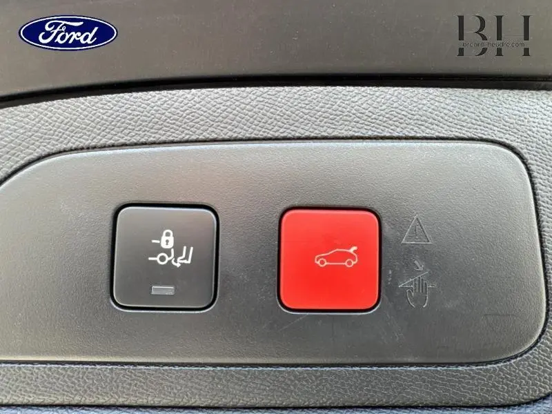 Gros plan sur les boutons de commande du coffre et de verrouillage, tableau de bord noir du DS7 Crossback gris Artense.