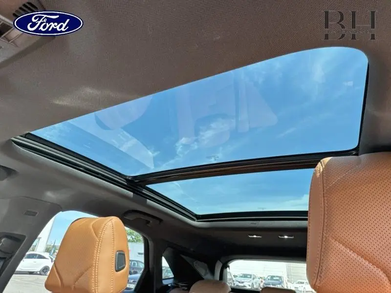 Vue intérieure du toit ouvrant panoramique du DS7 Crossback gris Artense avec sièges cuir brun Alezan.