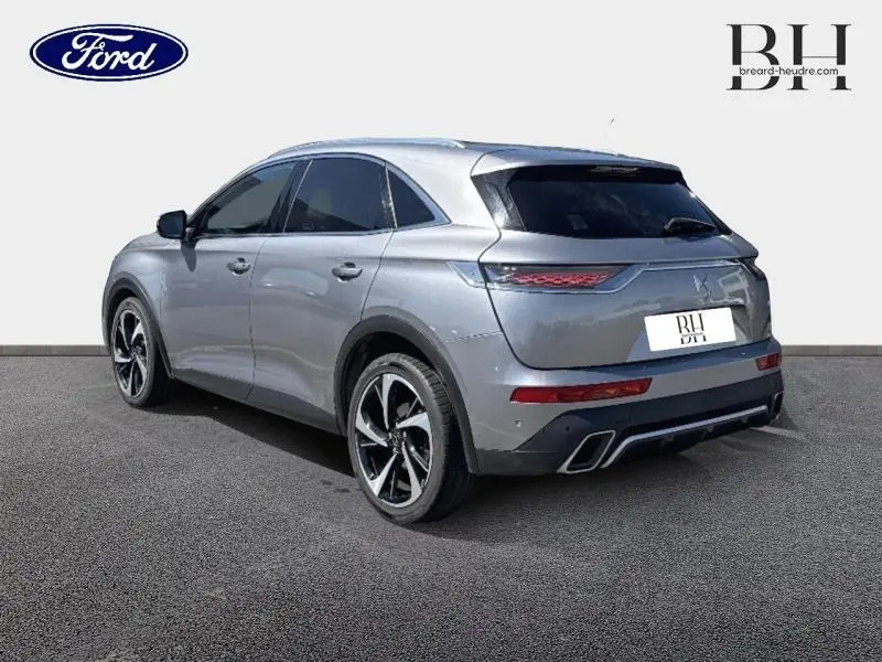 DS7 Crossback gris Artense vu en 3/4 arrière droit, avec jantes noires et feux arrière LED distinctifs.