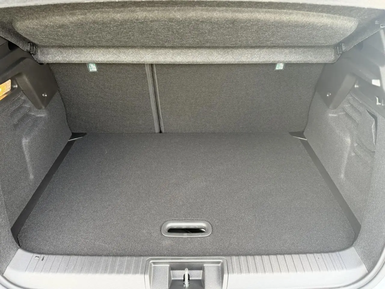 Coffre spacieux du Renault Captur gris Rafale, vue intérieure arrière avec plancher de coffre mobile fermé.