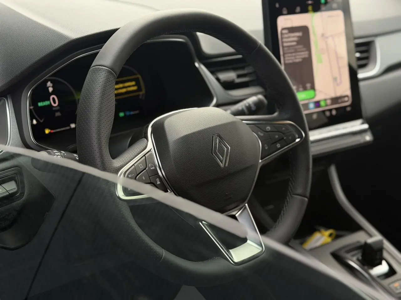 Vue rapprochée du volant noir textile du Renault Captur 2026 avec tableau de bord numérique et écran tactile central.