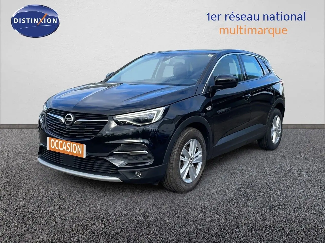 Opel Grandland X noir diamant métal en 3/4 avant droit sur sol gris, avec calandre et phares LED visibles.
