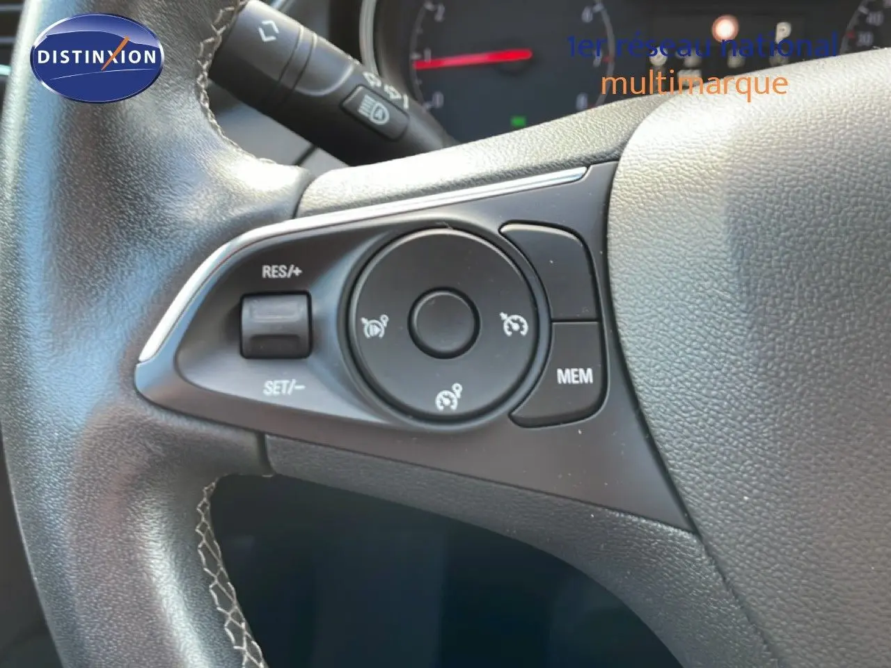 Gros plan sur les commandes de régulateur de vitesse au volant cuir noir de l’Opel Grandland X 2021.