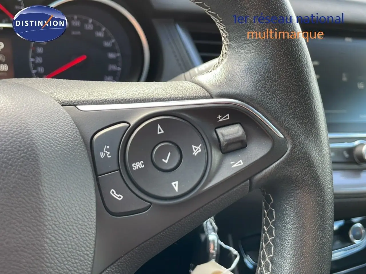 Gros plan sur le volant en cuir noir de l’Opel Grandland X 2021, avec commandes audio et téléphone intégrées.