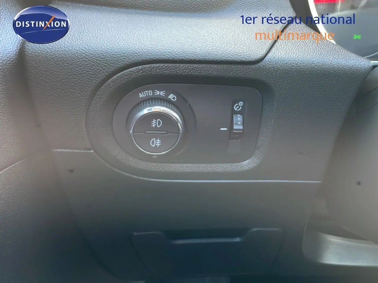 Gros plan sur le tableau de bord noir de l'Opel Grandland X 2021, montrant la commande des phares et réglage de luminosité.