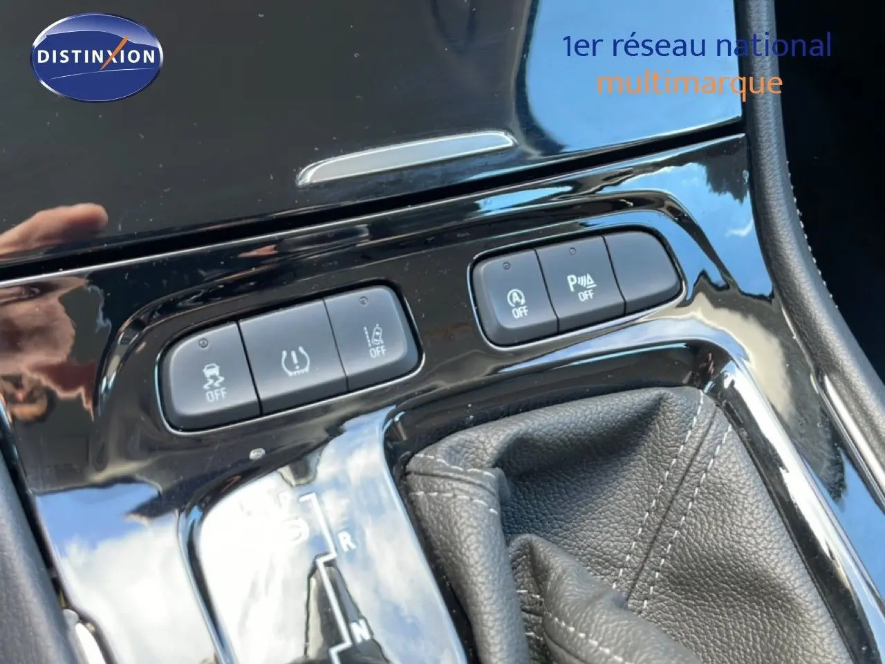 Gros plan sur la console centrale noire brillante de l’Opel Grandland X 2021, montrant les boutons de contrôle et le levier de boîte automatique.