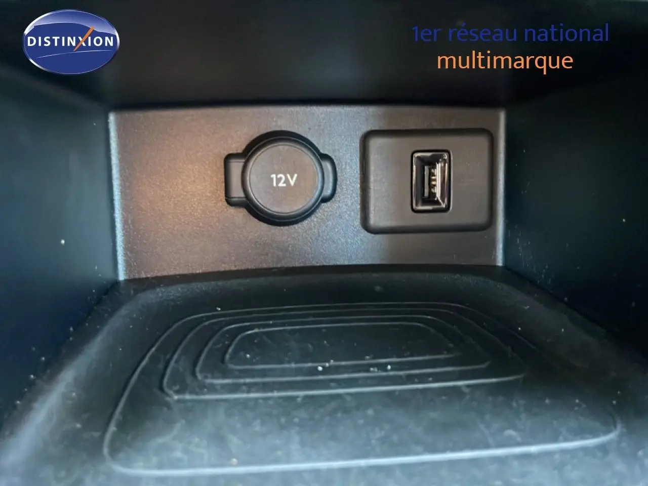 Prise 12V et port USB en gros plan dans le compartiment de rangement intérieur de l’Opel Grandland X noir diamant métal.