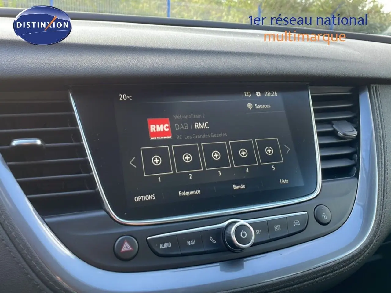 Vue rapprochée de l’écran tactile central de l’Opel Grandland X noir, affichant la radio DAB/RMC avec commandes intégrées.