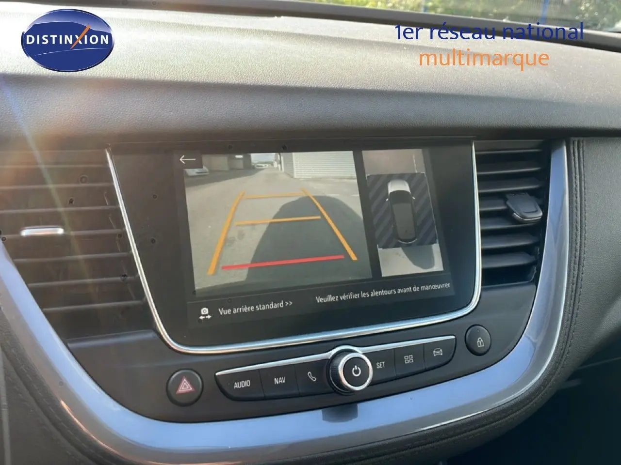 Vue intérieure du tableau de bord de l’Opel Grandland X noir diamant, écran affichant la caméra de recul et l’aide au stationnement.