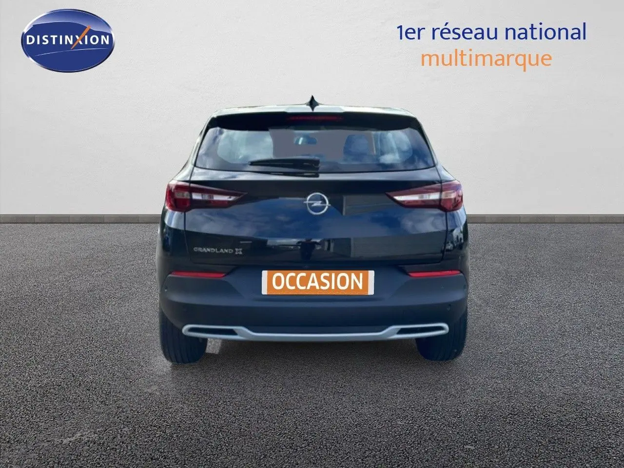 Vue arrière d'un Opel Grandland X noir diamant métal avec logo et feux arrière allongés, sur fond neutre.