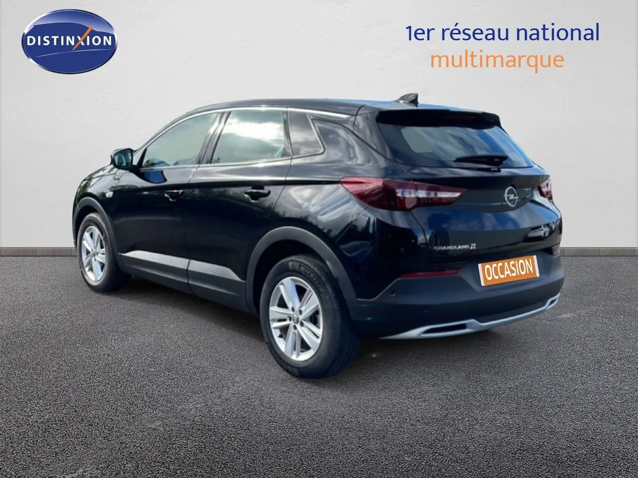 Opel Grandland X noir diamant métal en 3/4 arrière droit, avec jantes alliage et logo arrière visible.