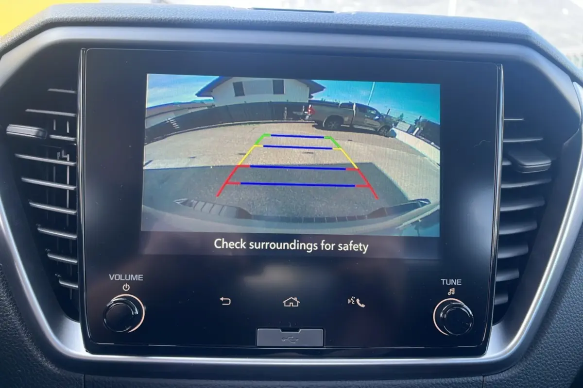 Écran tactile du tableau de bord montrant la caméra de recul du pick-up Isuzu D-MAX gris Kinabalu en marche arrière.