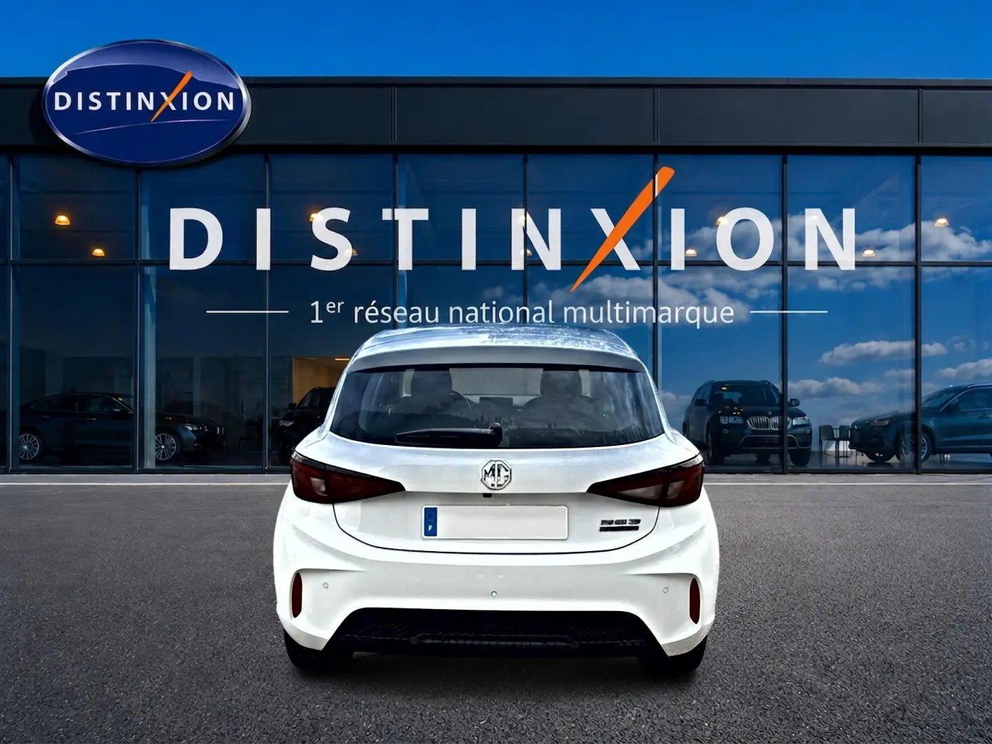 Vue arrière d'une MG3 1.5 hybrid 195 luxury blanche garée devant une vitrine avec logo Distinxion.