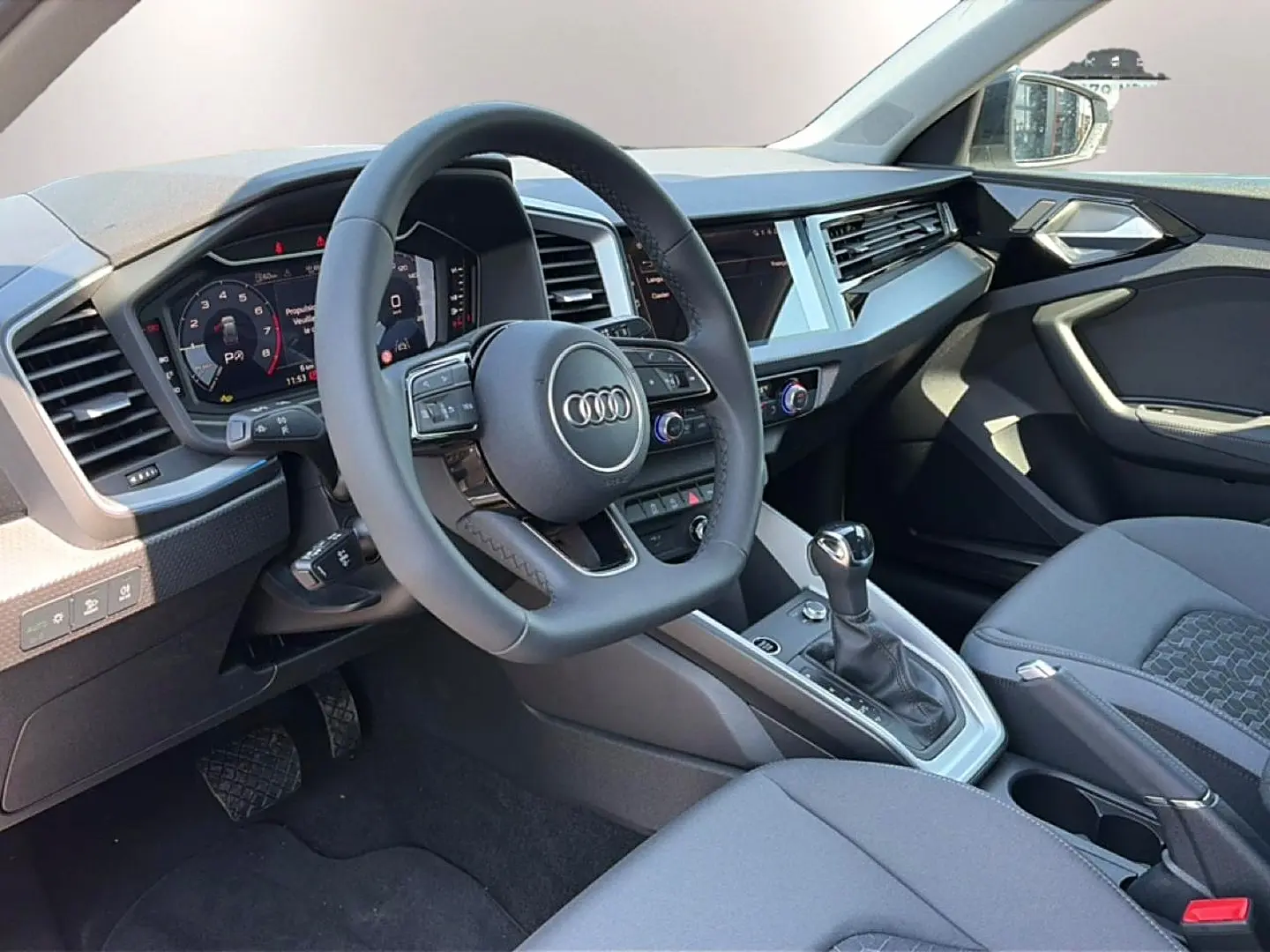 Vue intérieure côté conducteur de l’Audi A1 Sportback 30 TFSI 116 S line 2026 avec volant cuir multifonction et écran tactile.