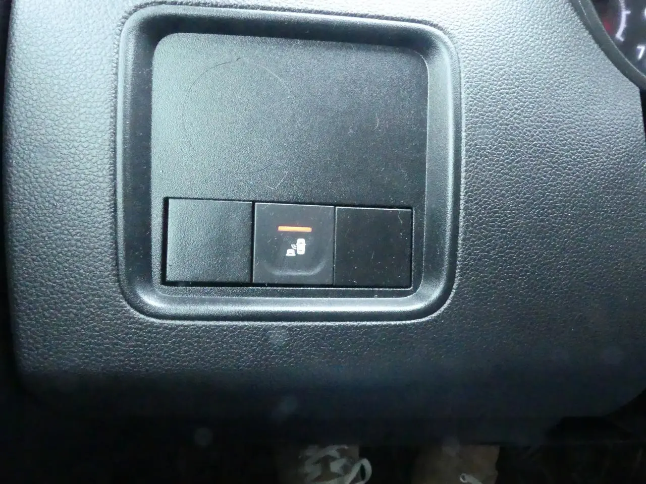 Gros plan sur le bouton de verrouillage centralisé dans l'habitacle noir du Dacia Duster 2023 version Extreme.