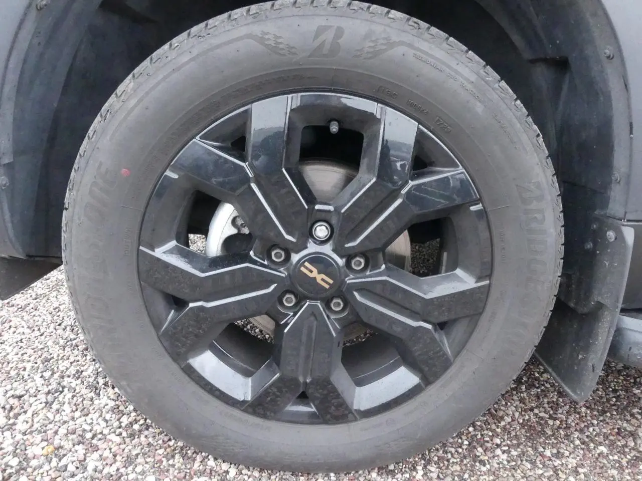 Gros plan sur la jante alliage noire 17 pouces du côté avant droit du Dacia Duster noir 2023.