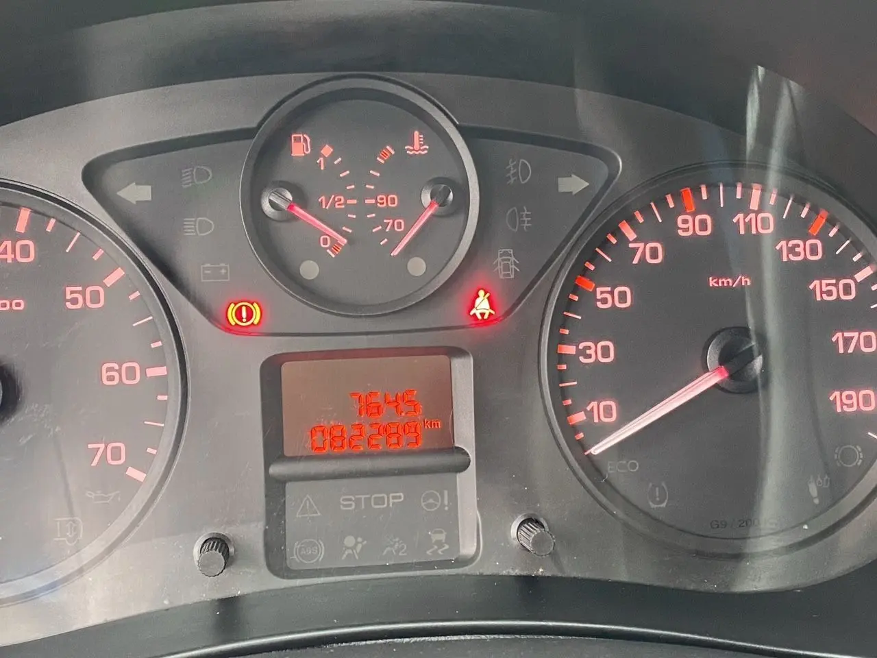 Tableau de bord du Citroën Berlingo blanc 2018, affichant le compteur de vitesse et les voyants allumés en rouge.