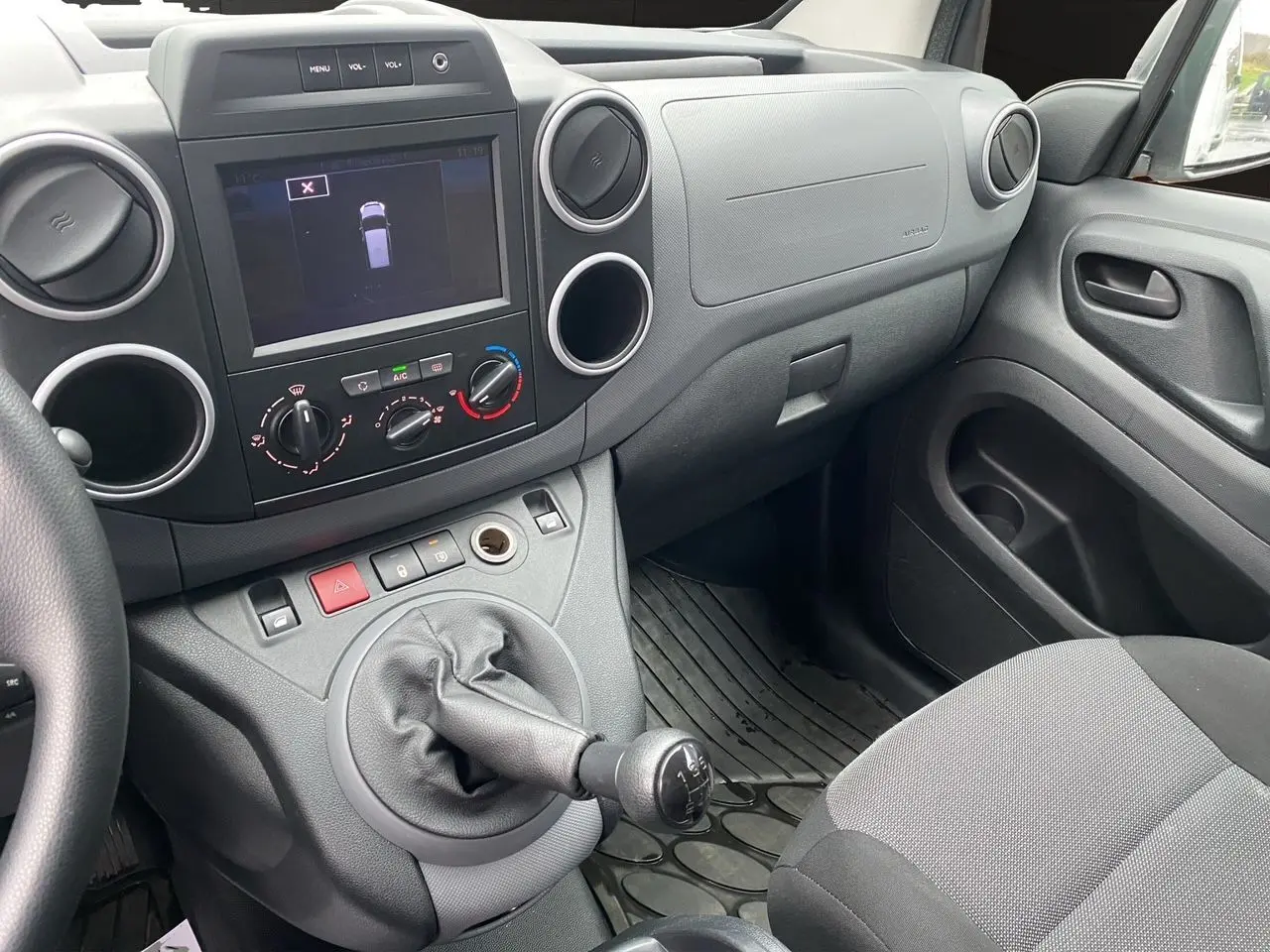 Vue intérieure côté passager du tableau de bord et levier de vitesses manuel du Citroën Berlingo blanc 2018.