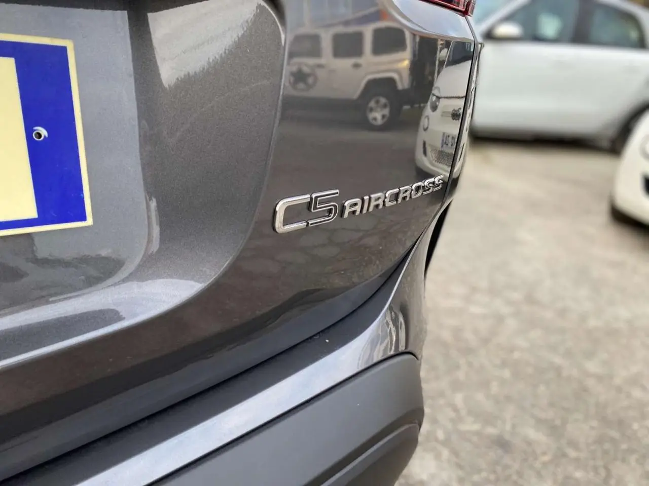 Gros plan sur l'arrière droit gris platinium du Citroën C5 Aircross avec le logo du modèle visible.