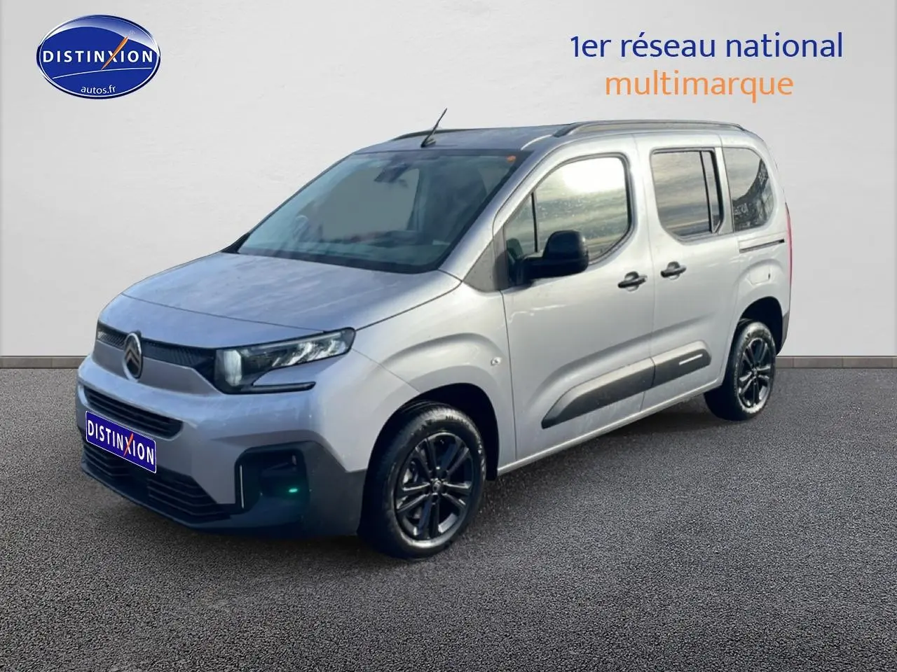 Citroën Berlingo gris Artense vu 3/4 avant droit avec jantes alu et barres de toit noires.