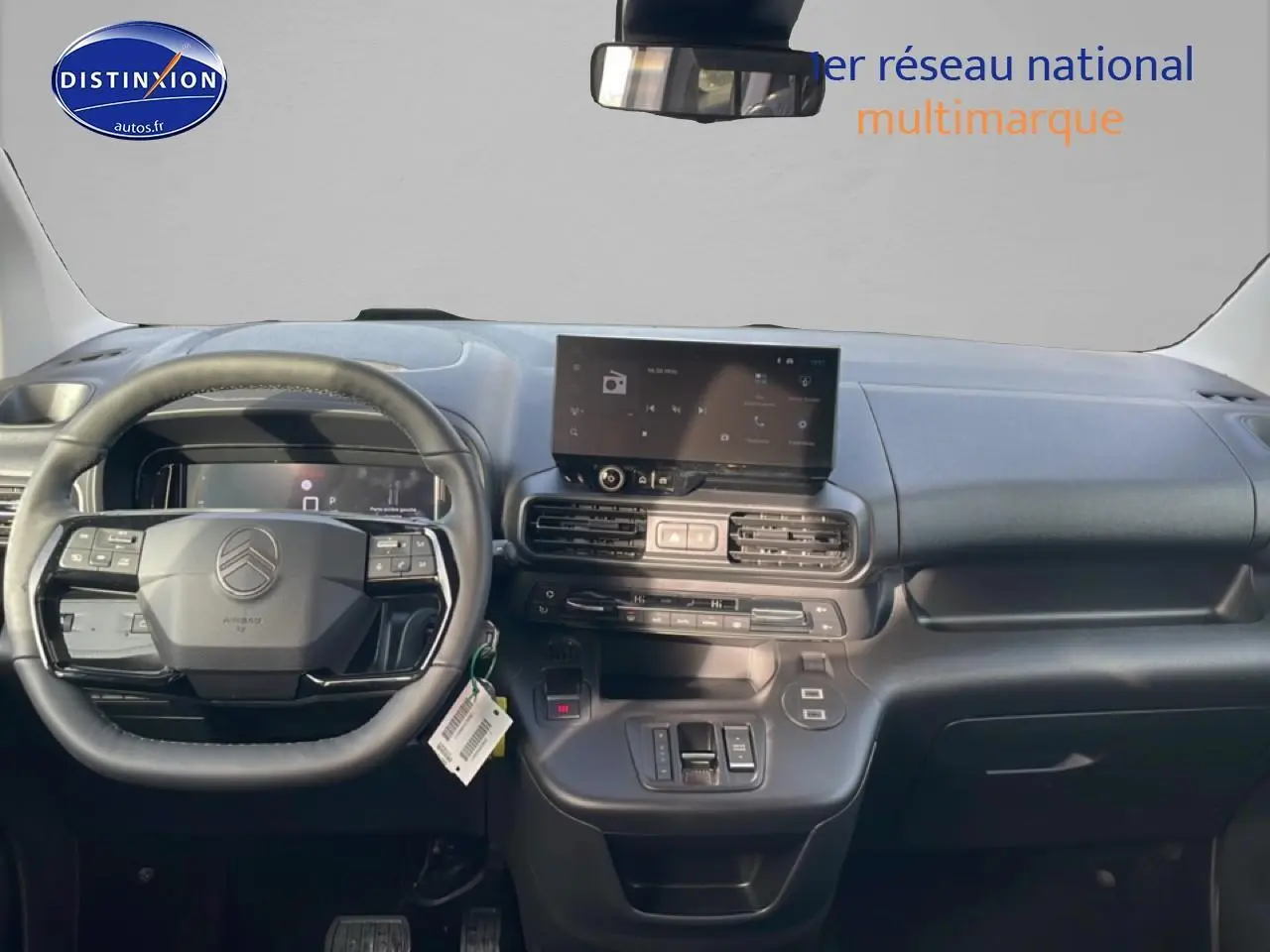 Vue intérieure frontale du tableau de bord gris du Citroën Berlingo 2025 avec écran tactile et volant multifonction.