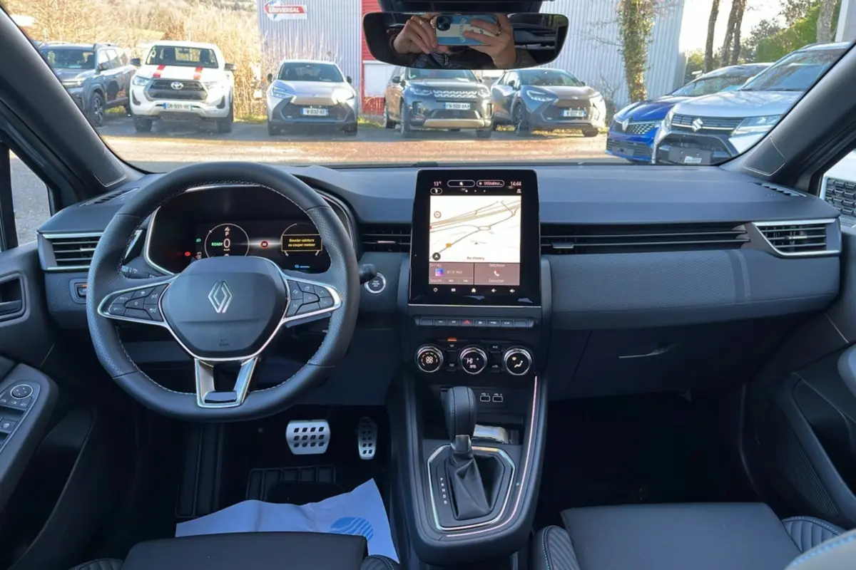 Vue intérieure avant de la Renault Clio V E-Tech 145 Esprit Alpine 2025, avec tableau de bord numérique et écran tactile central.