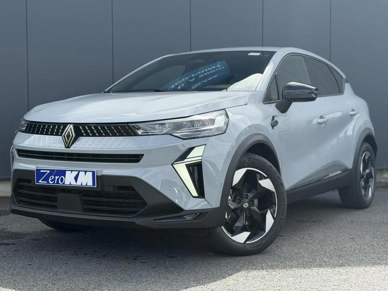 Renault Captur gris Rafale en 3/4 avant droit, avec jantes noires et détails lumineux distinctifs.