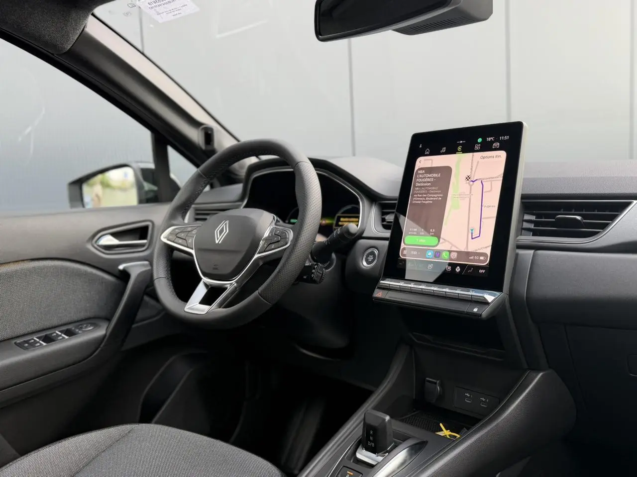 Vue intérieure côté conducteur du Renault Captur gris Rafale 2026, avec volant multifonction et écran tactile vertical.