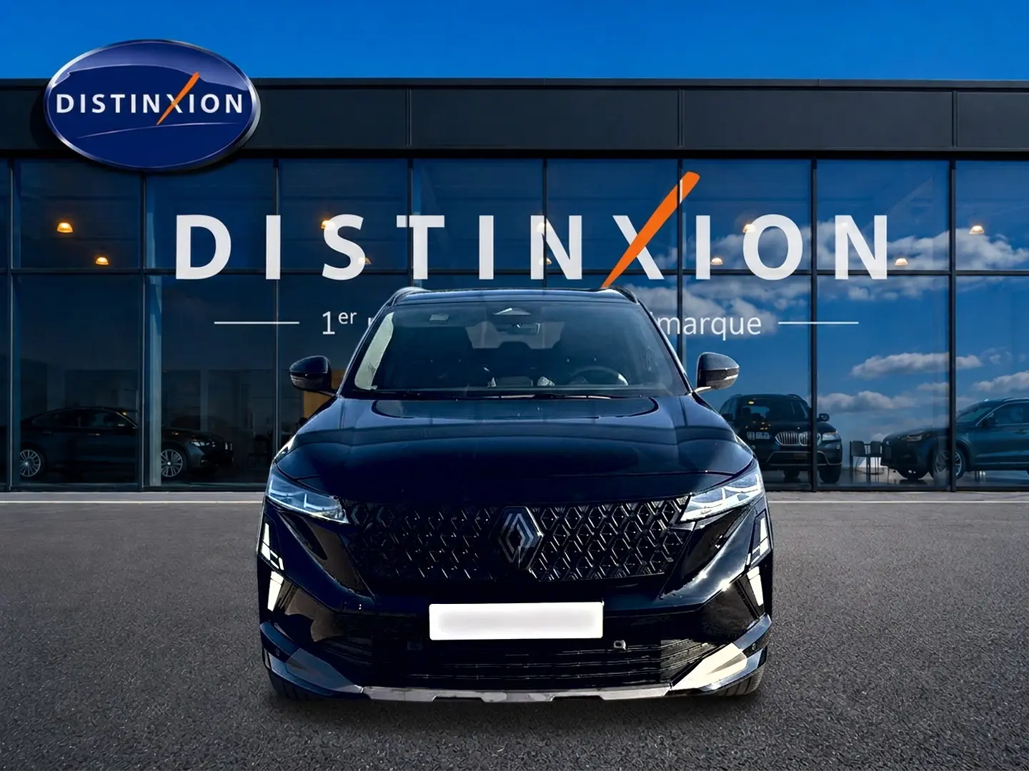 Vue avant d'un Renault Austral noir avec calandre distinctive et phares LED, devant une vitrine "Distinxion".