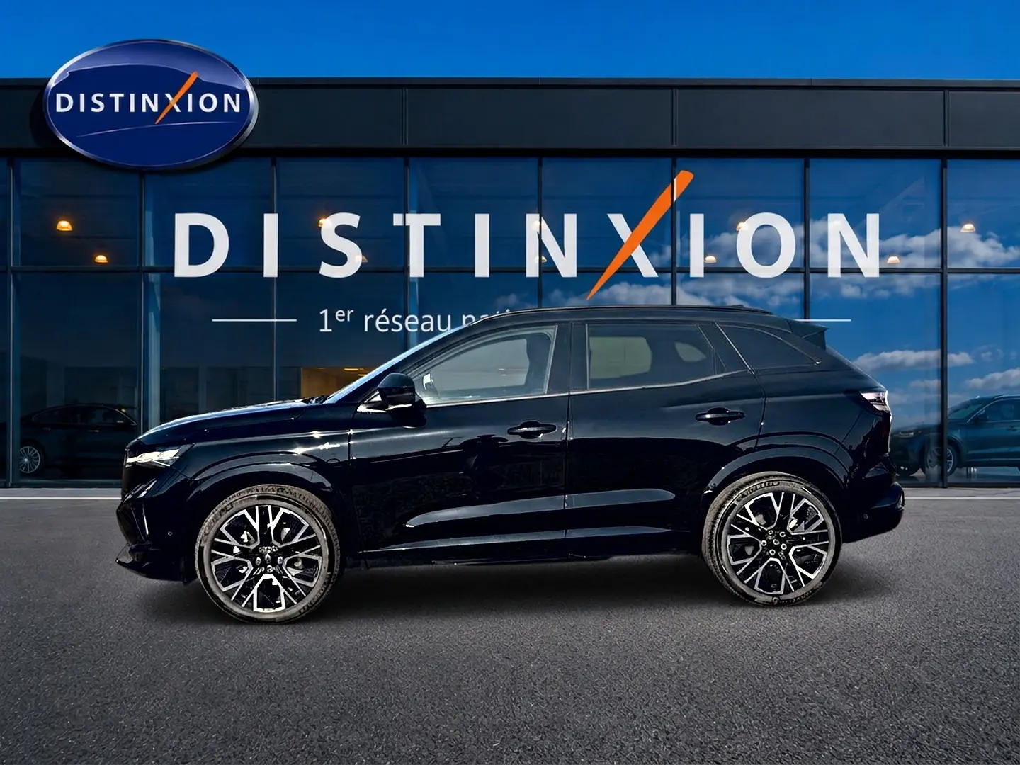 Profil droit du Renault Austral noir 2026 avec jantes alliage distinctives, devant une vitrine Distinxion.