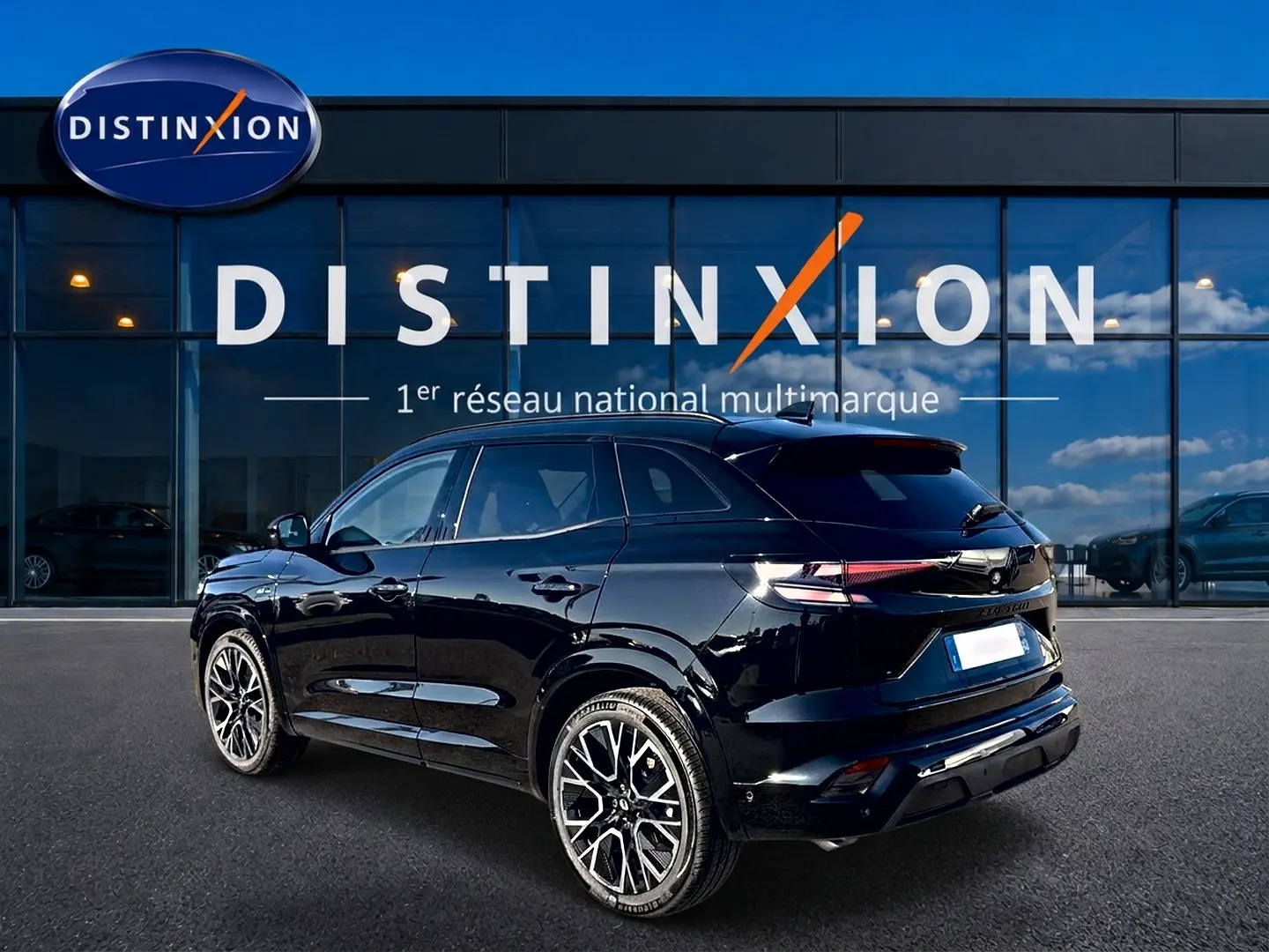 Renault Austral noir en 3/4 arrière droit, avec jantes alu distinctives et feux arrière LED allumés.