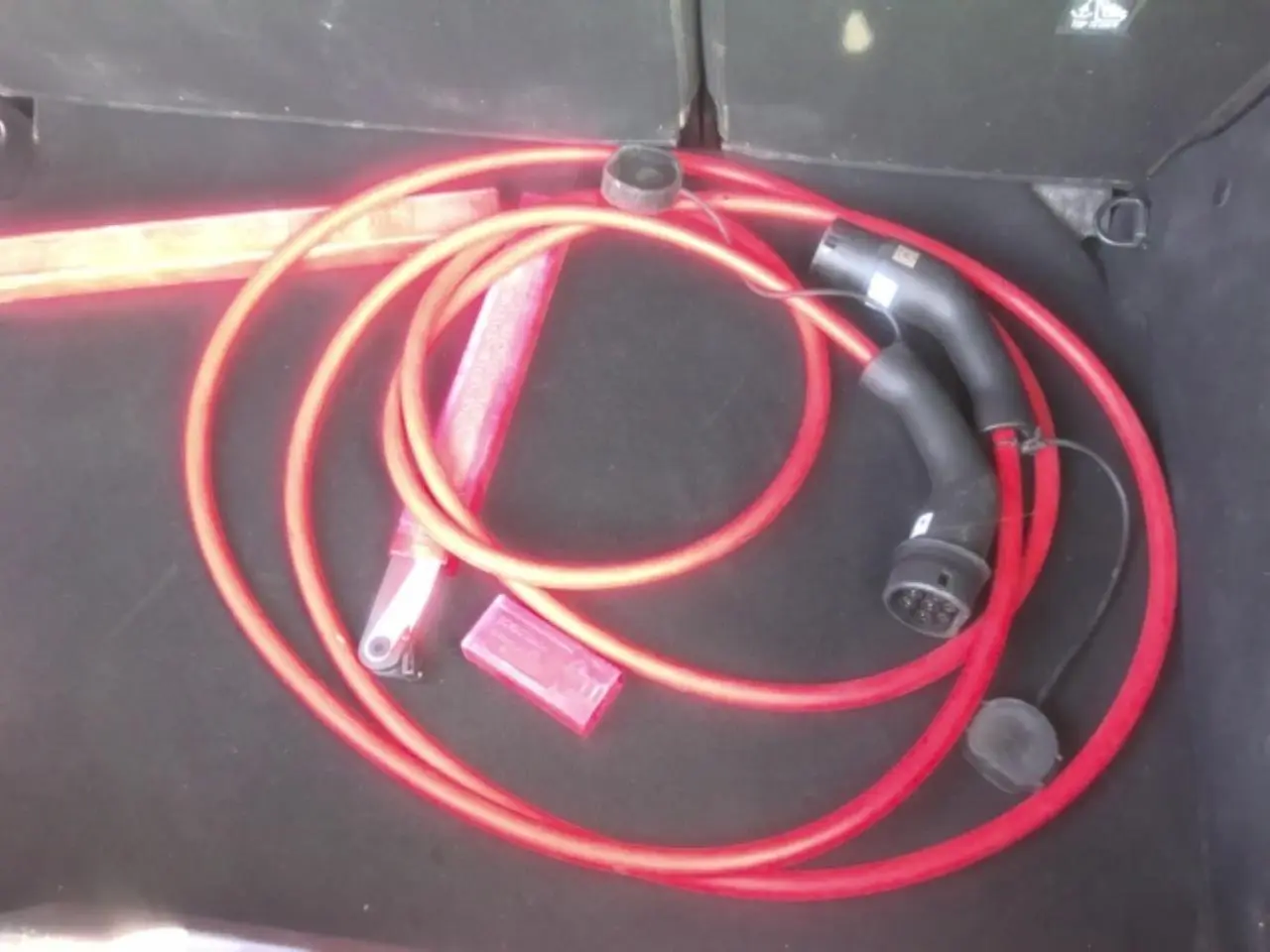 Câble de recharge électrique rouge dans le coffre noir d'une Citroën C3 ë-113 BERLINE Max 2025.