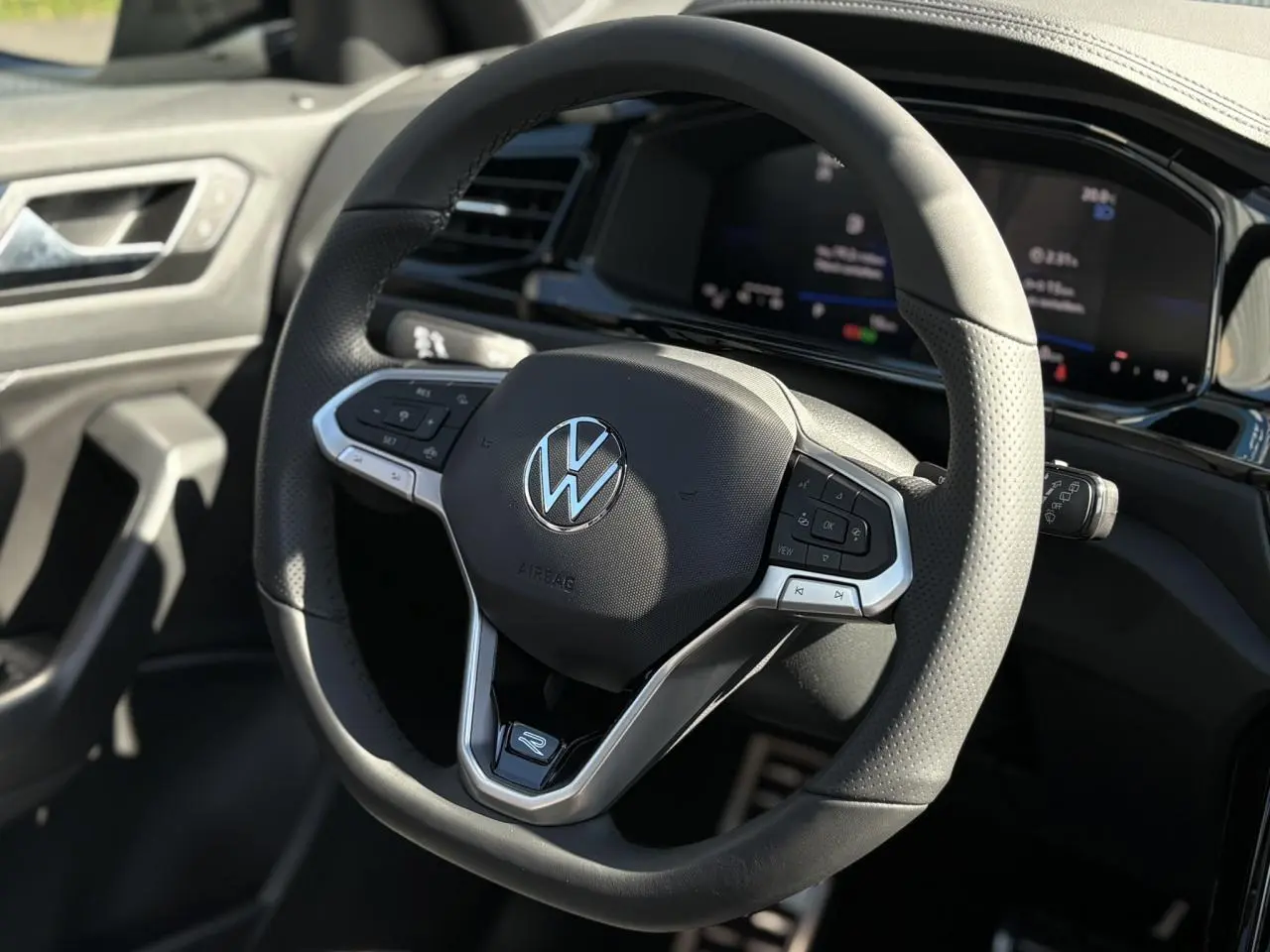 Volant sport multifonction noir avec logo VW, vue rapprochée de l'intérieur du Volkswagen T-Roc 2025 R-Line.