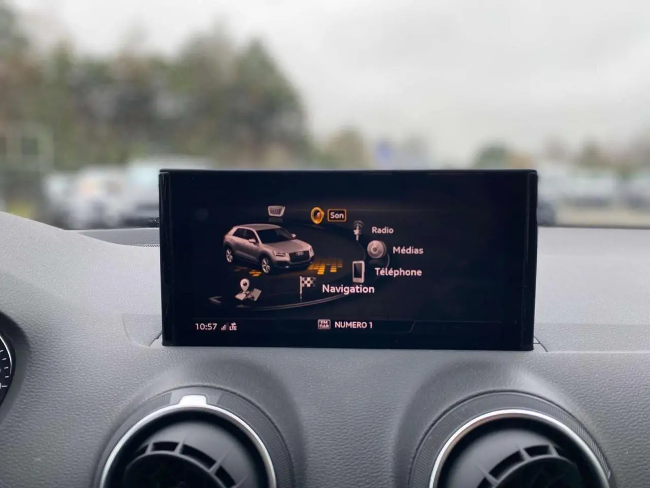 Écran central de navigation Audi Q2 2023 affichant les options son, radio, médias et téléphone, intérieur gris.