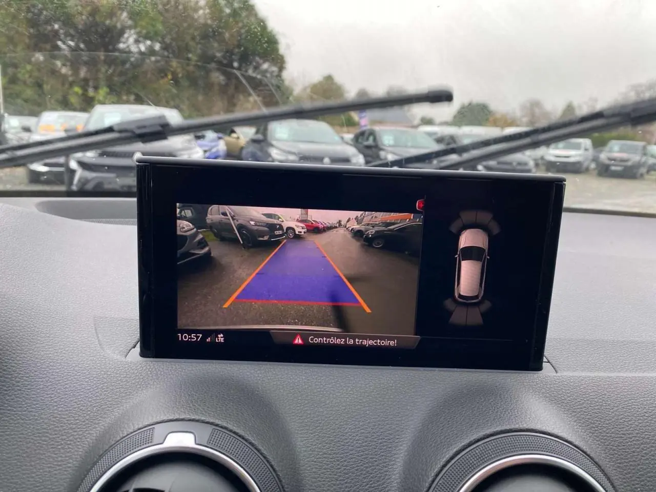 Vue intérieure du tableau de bord de l'Audi Q2 noir 2023, écran caméra de recul avec guidage de trajectoire visible.