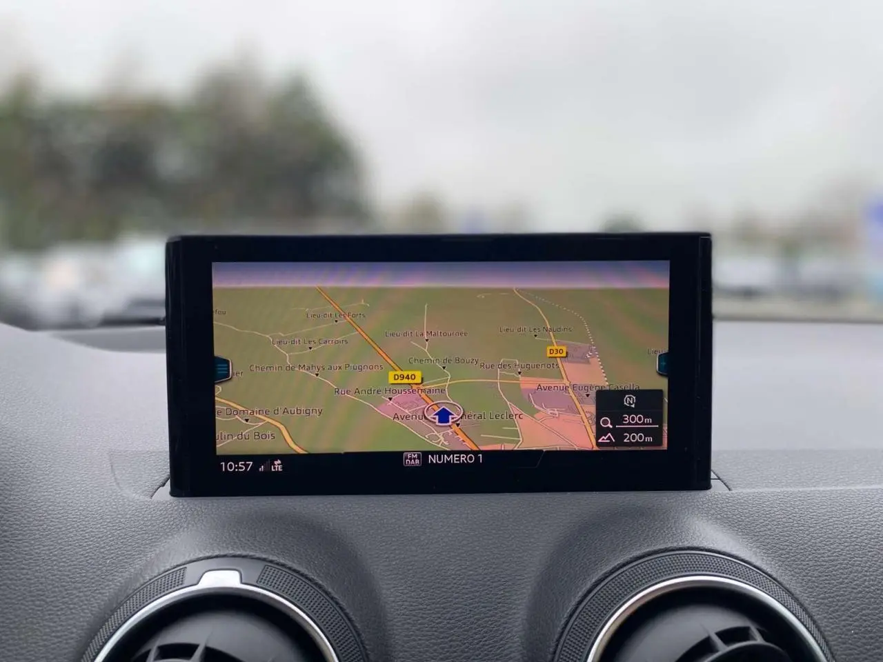 Vue rapprochée de l’écran de navigation MMI sur le tableau de bord de l’Audi Q2 noir, affichant une carte détaillée.