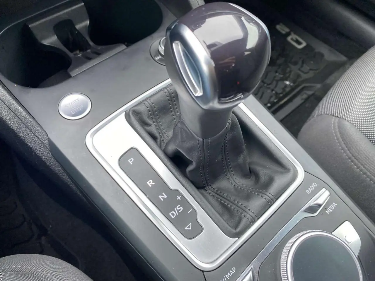 Gros plan sur le levier de vitesses automatique noir et argenté de l’Audi Q2 2023, avec commandes MMI autour.