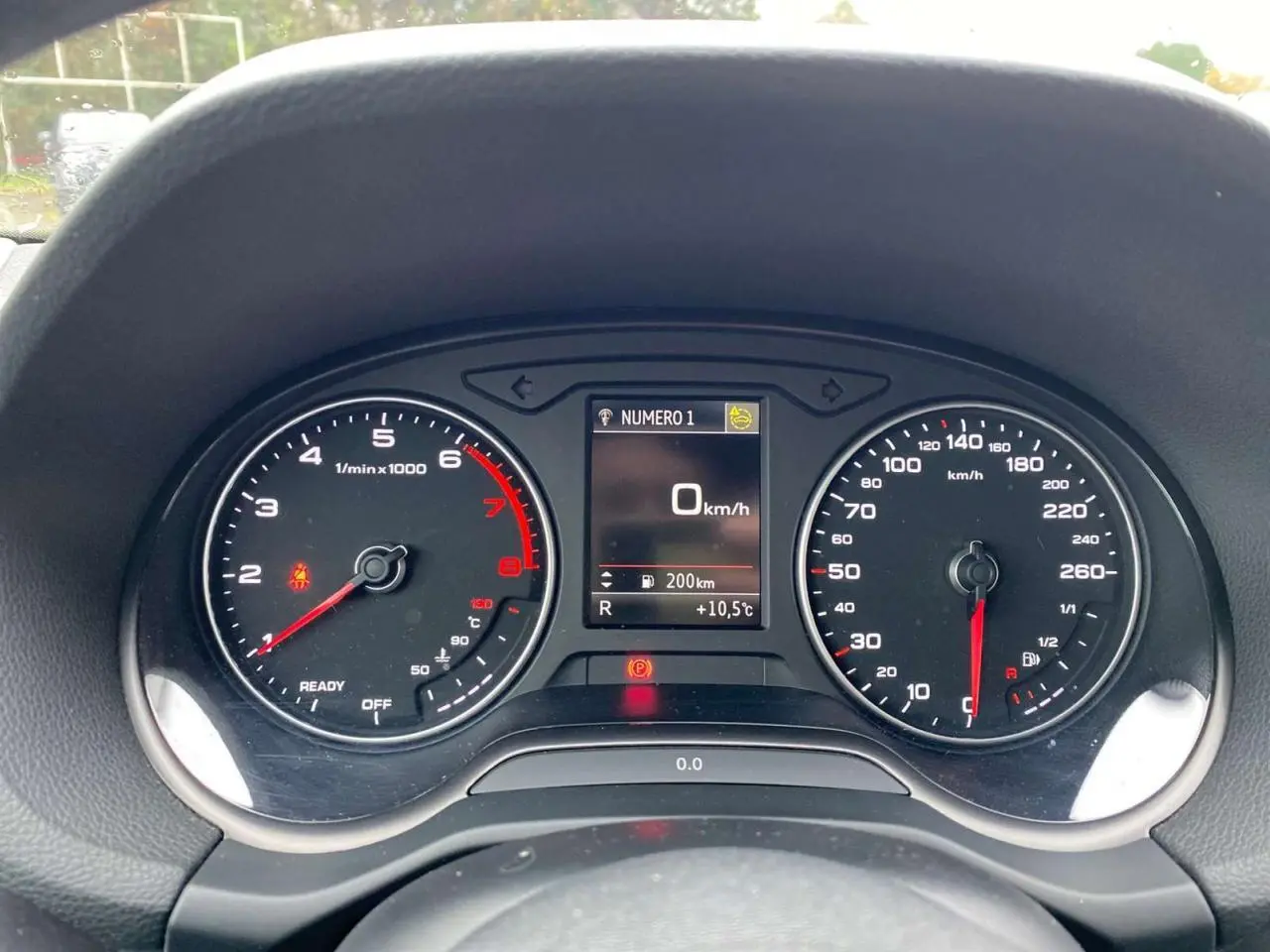 Vue rapprochée du combiné d'instruments Audi Q2 2023, affichage digital au centre, compte-tours et compteur de vitesse analogiques.