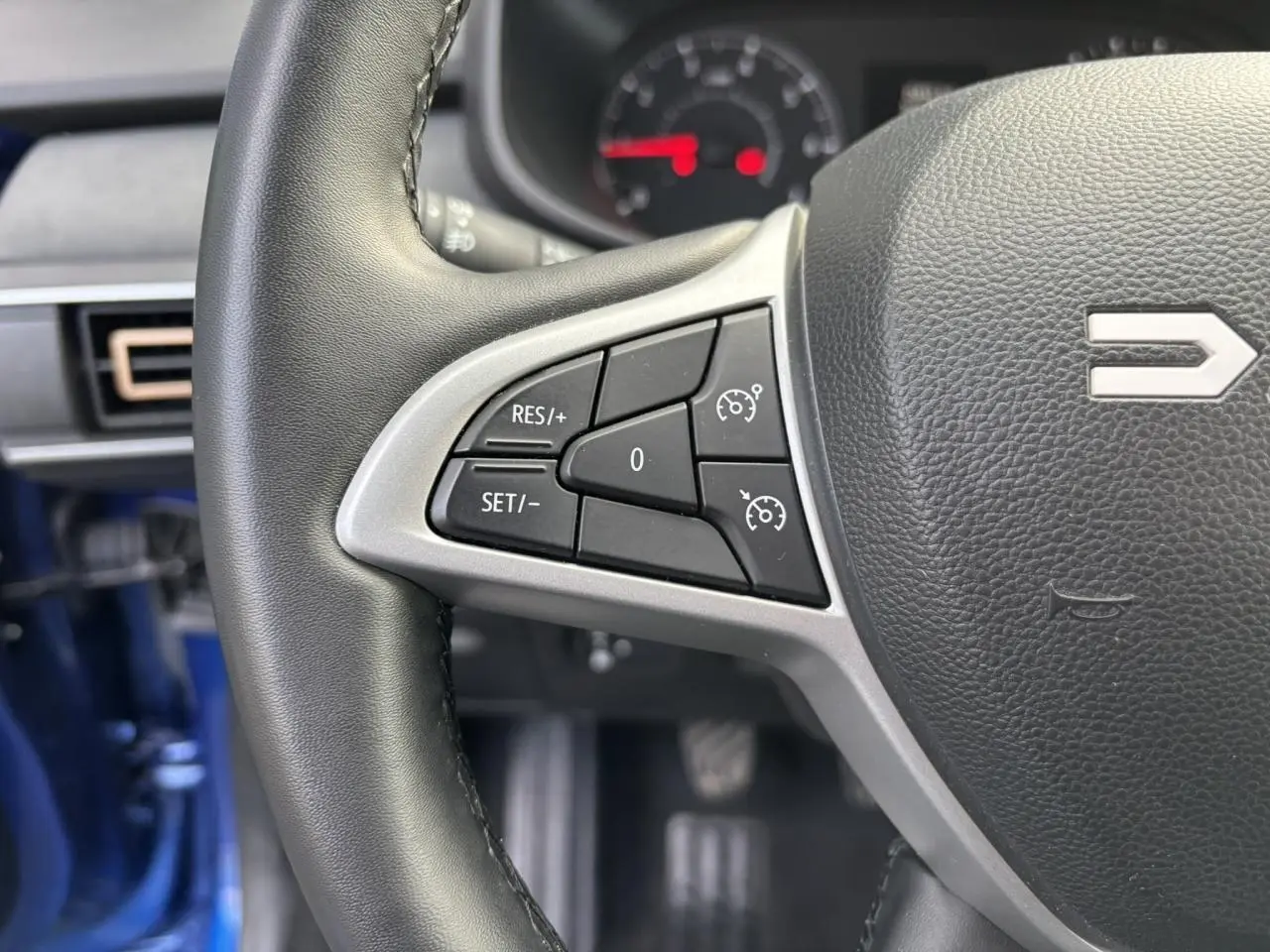 Gros plan sur le volant côté gauche du Dacia Sandero Stepway Bleu Iron 2025 avec commandes de régulateur de vitesse.