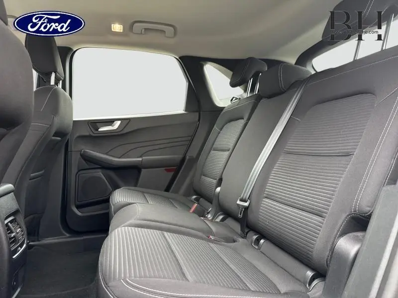 Vue intérieure côté droit de la banquette arrière noire du Ford Kuga 2023, avec ceintures et appuie-têtes visibles.