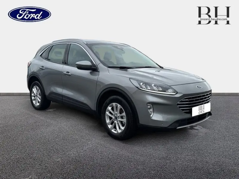 Ford Kuga gris Solar métallisé en vue 3/4 avant droit, avec jantes alliage et calandre noire distinctive.