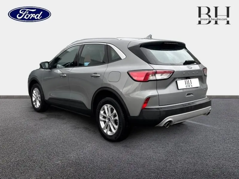 Ford Kuga gris Solar métallisé vu en 3/4 arrière droit, avec feux LED et double sortie d’échappement visible.