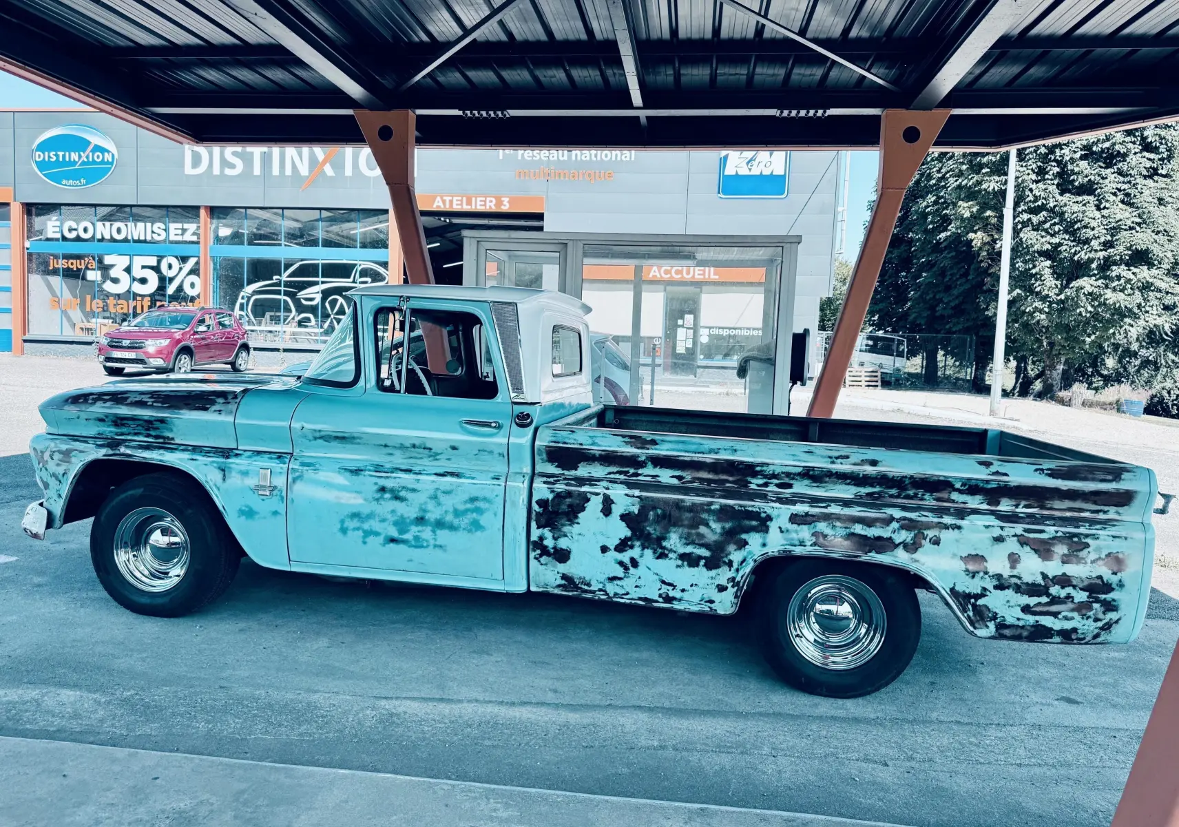 Vue de profil côté gauche d’un Chevrolet C10 Apache 1963 bleu patiné avec carrosserie vieillie et roues chromées.