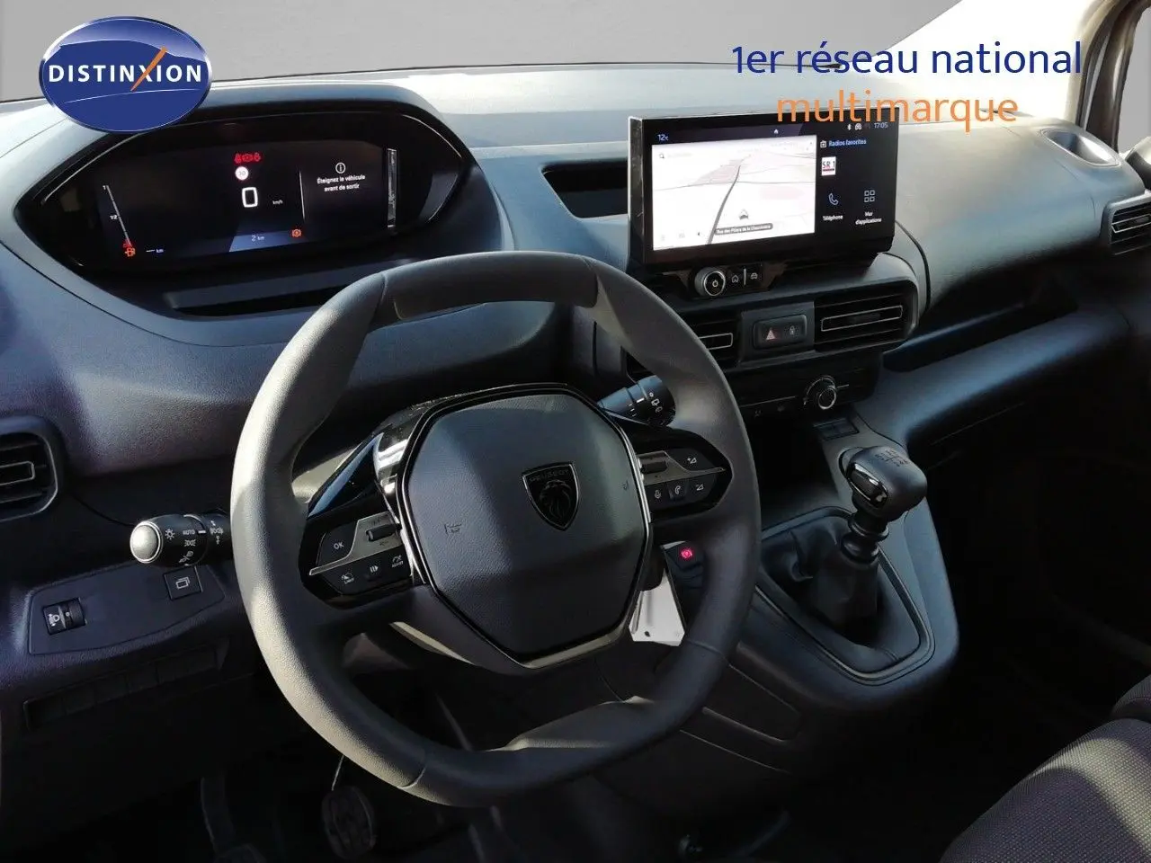 Vue intérieure du poste de conduite du Peugeot Partner 2026 blanc Kaolin, avec volant multifonction et écran tactile central.
