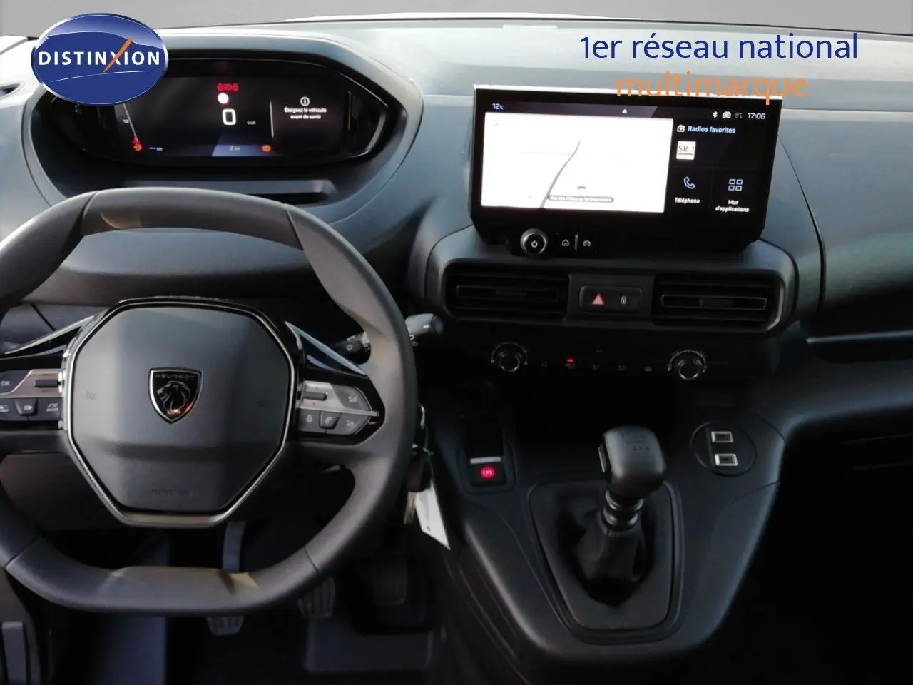 Vue intérieure centrée sur le volant et la console centrale du Peugeot Partner blanc Kaolin avec écran tactile et boîte manuelle.